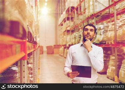 wholesale, logistic, people and export concept - businessman with clipboards at warehouse