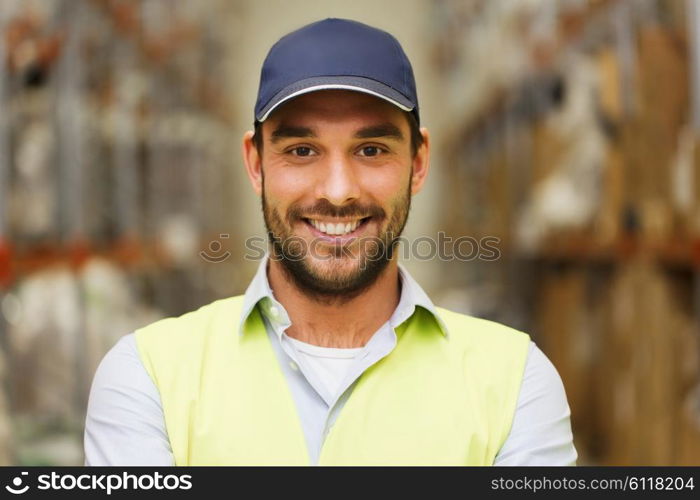 wholesale, logistic, people and export concept - happy man in cap and reflective safety vest at warehouse