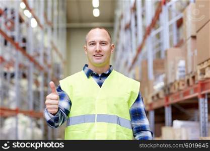 wholesale, logistic, people and export concept - happy man in reflective safety vest showing thumbs up gesture at warehouse