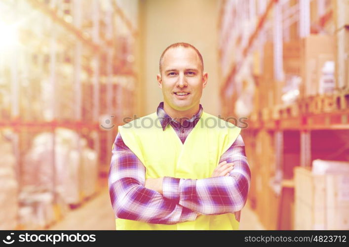 wholesale, logistic, people and export concept - happy man in reflective safety vest at warehouse