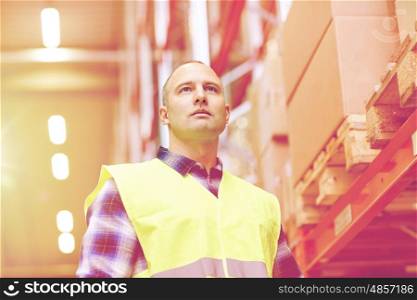 wholesale, logistic, people and export concept - man in reflective safety vest at warehouse