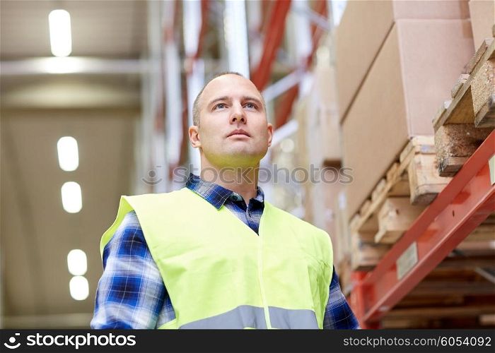 wholesale, logistic, people and export concept - man in reflective safety vest at warehouse