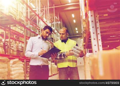 wholesale, logistic, people and export concept - manual worker and businessmen with clipboard and boxes at warehouse. worker and businessmen with clipboard at warehouse