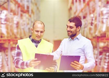 wholesale, logistic, people and export concept - manual worker and businessmen with clipboards at warehouse. worker and businessmen with clipboard at warehouse
