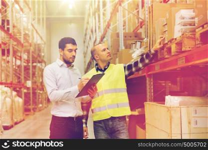 wholesale, logistic, people and export concept - manual worker and businessmen with clipboards at warehouse. worker and businessmen with clipboard at warehouse