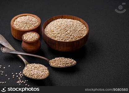 Wholesome raw quinoa in a bowl on a dark concrete background. Useful healthy food