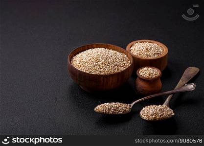 Wholesome raw quinoa in a bowl on a dark concrete background. Useful healthy food