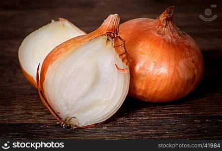 Wholly onion and two halves on a wooden table