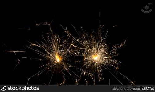 Wick with lit gunpowder from which many sparks come out on black background. Wick with lit gunpowder from which many sparks of yellow color on a black background
