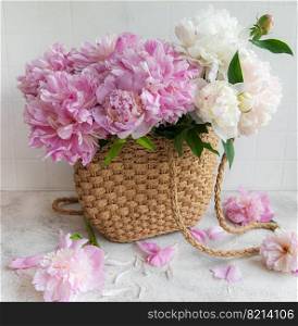 Wicker bag with peony flowers, summer floral concept.