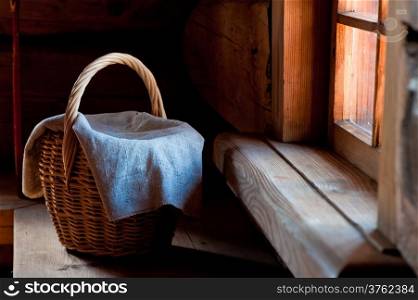 wicker basket covered with a rough cloth on the bench in the hut