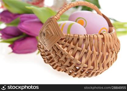 wicker basket of easter eggs with flowers
