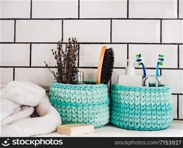 Wicker basket with bath accessories on a white ceramic tile background. Close-up indoor. Studio photo. Preparing for the Spa Treatment. Concept of beauty and health. Wicker basket with bath accessories. Spa Treatment