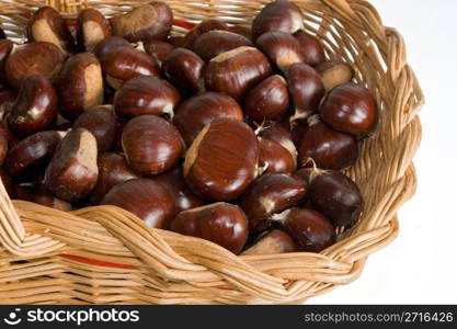 wicker basket with chestnuts isolated on white background