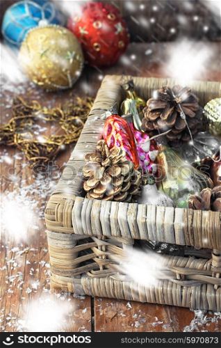Wicker basket with Christmas retro toys on a snowy background.Painted snow. Wicker basket with Christmas toys
