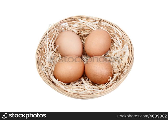 Wicker basket with four eggs on straw isolated on white background