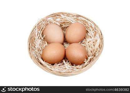 Wicker basket with four eggs on straw isolated on white background