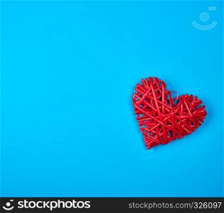 wicker red heart on a blue background, copy space