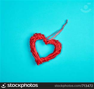 wicker red heart on a blue background, copy space, close up