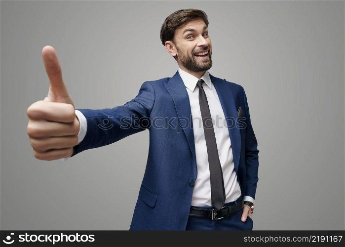 wide angle selfie studio shot of young business man going thumb up on grey background. wide angle selfie shot of young business man going thumb up on grey background