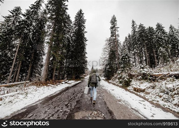 wide angle. tourist man with a backpack going through a snowy forest.. tourist man with a backpack going through a snowy forest. wide angle