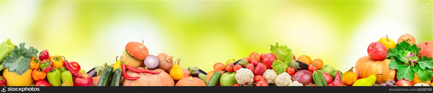 Wide collage of fresh fruits and vegetables on green blur background. Copy space.