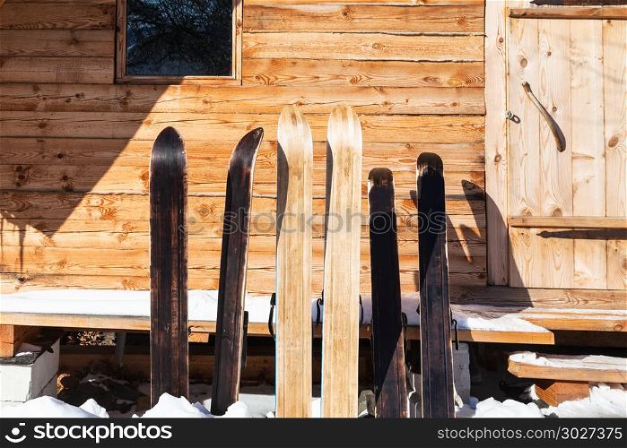 wide forest skis in front of wooden cottage. wide forest skis in front of wooden cottage in sunny winter day in russian village in Smolensk region of Russia