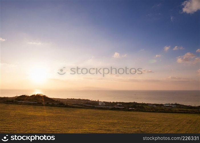Wide Grass field by the ocean at sunset or sunrise in Ishigaki island, Okinawa, Japan