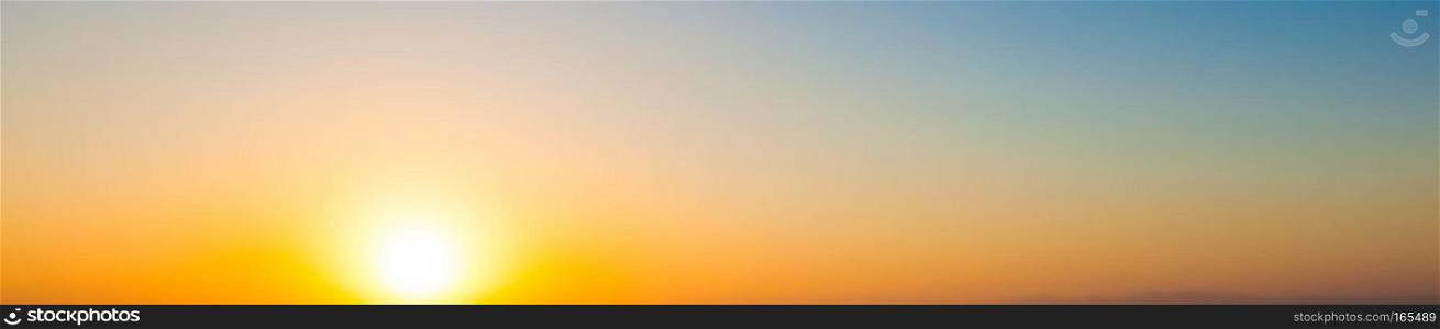 Wide panorama sunset background. Clear sky with setting sun and warm gradient colors. Wide panorama sunset background. Clear sky