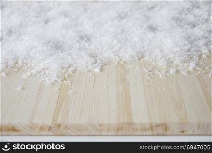 Wide surface of pine wood covered with white fluffy snow. Background for decoration and design