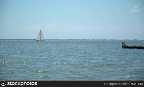 Wide view of a sail boat drifting in the ocean