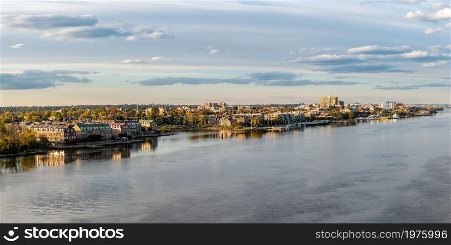 Wide view of the historic city of Alexandria and the waterfront property along the Potomac River in northern Virginia. Waterfront of city of Alexandria in Virginia at sunset