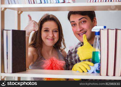 Wife and husband cleaning dust from bookshelf