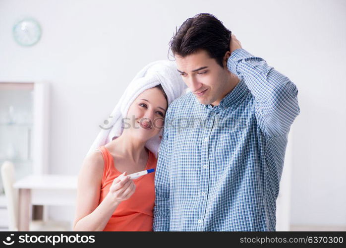 Wife and husband looking at pregnancy test