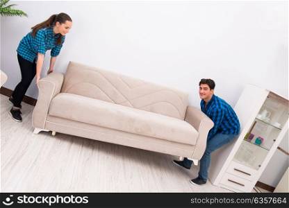 Wife and husband moving sofa couch