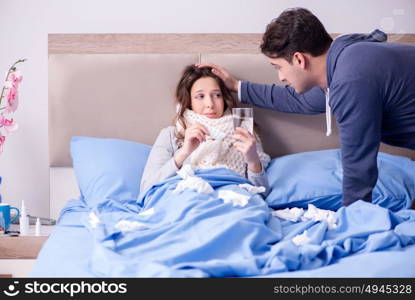 Wife caring for sick husband at home in bed