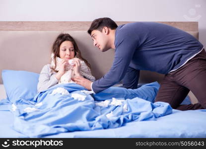 Wife caring for sick husband at home in bed