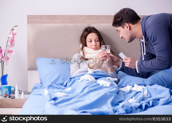 Wife caring for sick husband at home in bed