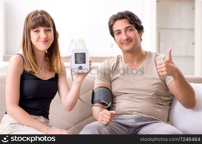 Wife checking husband&rsquo;s blood pressure  . Wife checking husband&rsquo;s blood pressure 