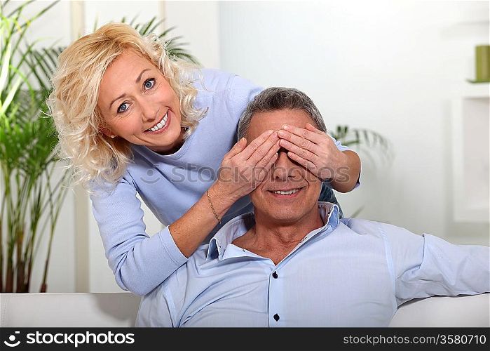 wife covering her husband&acute;s eyes