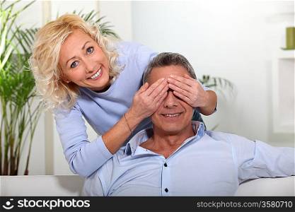 wife covering her husband&acute;s eyes