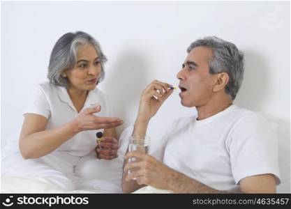 Wife giving medication to husband