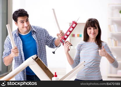 Wife helping husband to repair broken chair at home