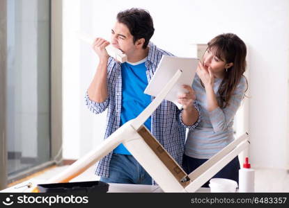 Wife helping husband to repair broken chair at home