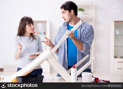 Wife helping husband to repair broken chair at home