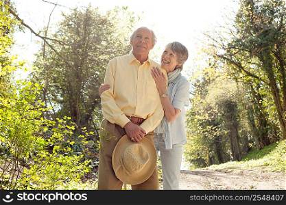 Wife posing with husband holding her straw hat