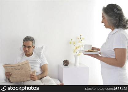 Wife serving tea to her husband