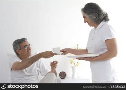 Wife serving tea to her husband