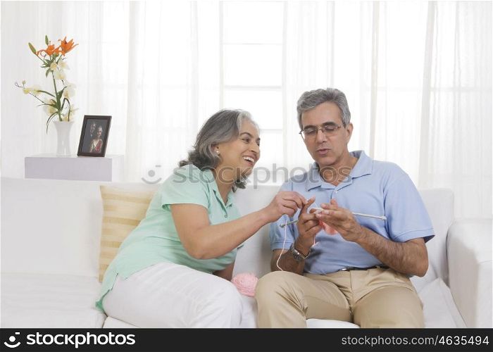 Wife teaching her husband knitting