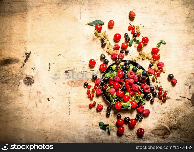 Wild berries in the old plate. On a wooden table.. Wild berries in the old plate. On wooden table.